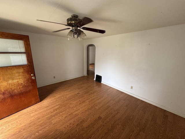 7715 18th Ave, Kenosha, WI 53143 - empty room featuring arched walkways, wood finished floors, ceiling fan, and baseboards