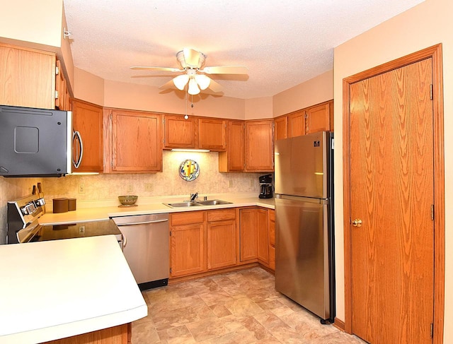 10320 W Whitnall Edge Cir Unit A, Franklin, WI 53132 - kitchen with appliances with stainless steel finishes, a ceiling fan, a sink, light countertops, and brown cabinets
