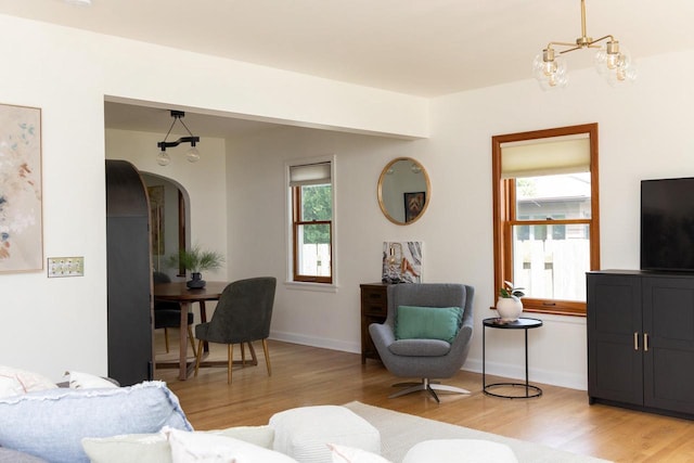 2707 Mason St, Madison, WI 53705 - living area featuring light wood-style floors, arched walkways, and a chandelier