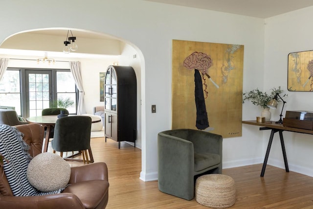 2707 Mason St, Madison, WI 53705 - living area featuring arched walkways, light wood-style flooring, and a chandelier