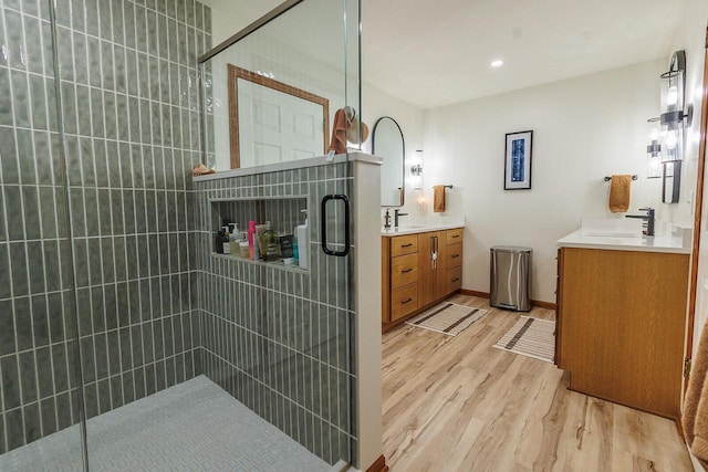 6633 W Beacon Hill Pl, Franklin, WI 53132 - bathroom featuring wood finished floors, tiled shower, and two vanities