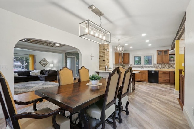 N62W23527 Sliver Spring Dr, Sussex, WI 53089 - dining space with arched walkways, light wood-style flooring, healthy amount of natural light, and recessed lighting