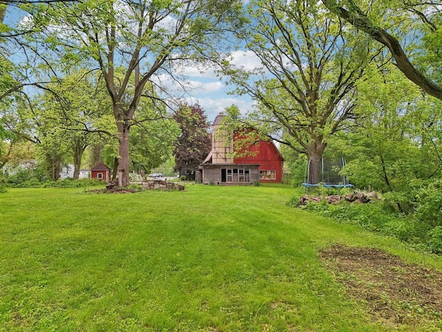 N62W23527 Sliver Spring Dr, Sussex, WI 53089 - view of grassy yard with a trampoline, an outbuilding, and a barn