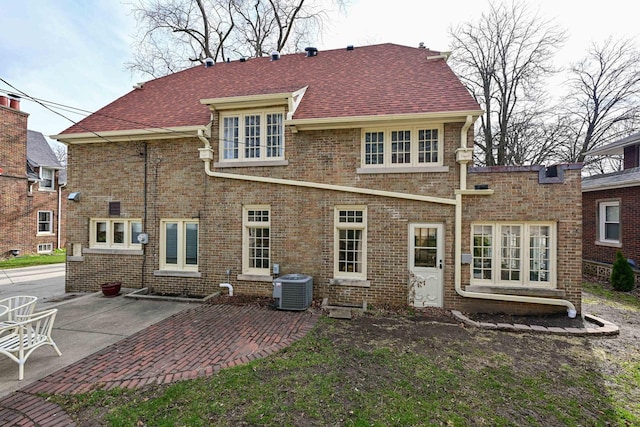 529 N 68th St, Wauwatosa, WI 53213 - rear view of house featuring central AC unit, a patio area, brick siding, and a shingled roof