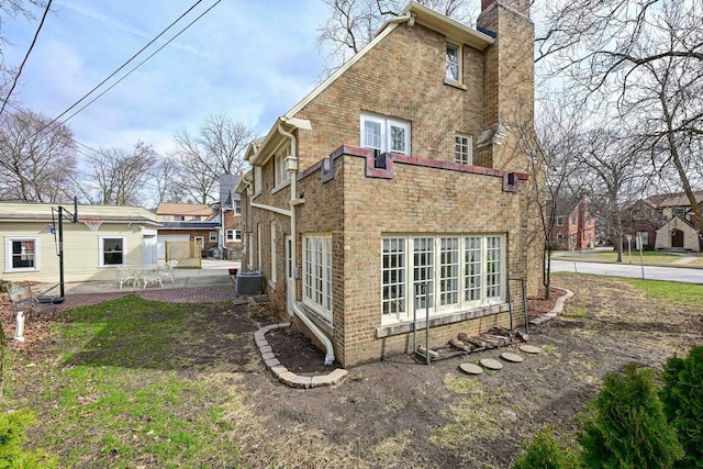 529 N 68th St, Wauwatosa, WI 53213 - back of property with a chimney, a patio, brick siding, and cooling unit