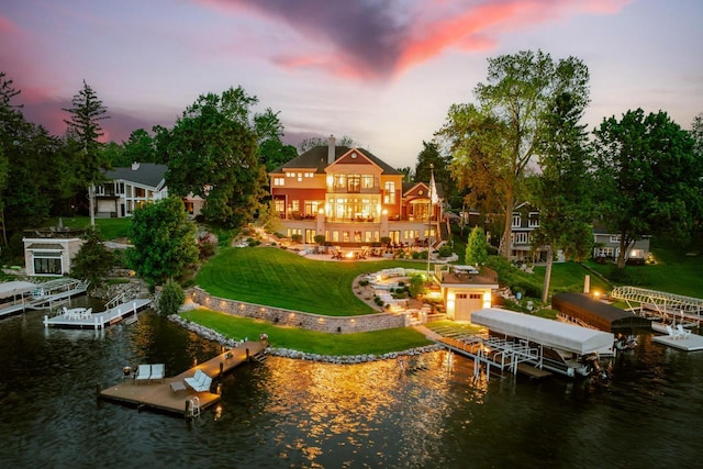 N49W35398 Wisconsin Ave, Oconomowoc, WI 53066 - back of property at dusk with a water view, boat lift, a yard, and a balcony
