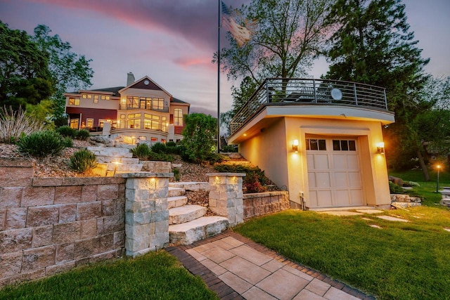 N49W35398 Wisconsin Ave, Oconomowoc, WI 53066 - view of front of home with a balcony, stucco siding, and a front yard