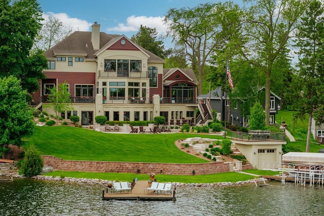 N49W35398 Wisconsin Ave, Oconomowoc, WI 53066 - rear view of property with a water view, a lawn, a chimney, a patio, and a balcony