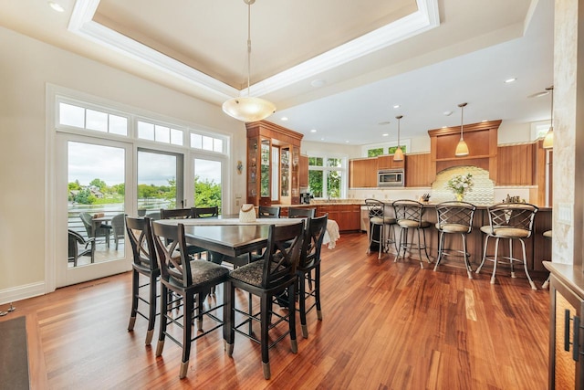 N49W35398 Wisconsin Ave, Oconomowoc, WI 53066 - dining space with a raised ceiling, wood finished floors, crown molding, and recessed lighting