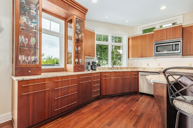 N49W35398 Wisconsin Ave, Oconomowoc, WI 53066 - kitchen featuring appliances with stainless steel finishes, a sink, dark wood-style floors, light stone counters, and recessed lighting