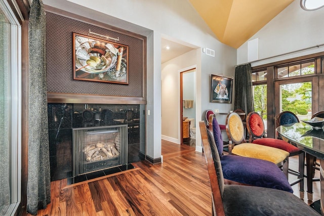 N49W35398 Wisconsin Ave, Oconomowoc, WI 53066 - dining space featuring wood finished floors, lofted ceiling, baseboards, and a premium fireplace