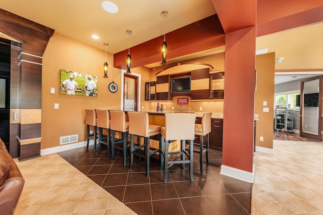 N49W35398 Wisconsin Ave, Oconomowoc, WI 53066 - dining area with dark tile patterned flooring, baseboards, bar with sink, and recessed lighting