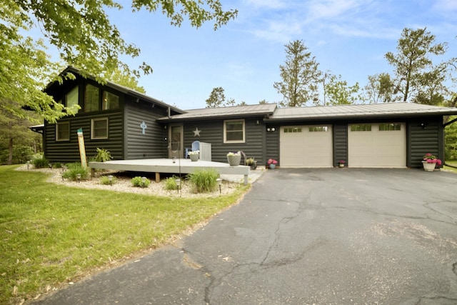 29774 Whispering Pines Rd, Lone Rock, WI 53556 - view of front of house featuring an attached garage, driveway, log veneer siding, and a front lawn