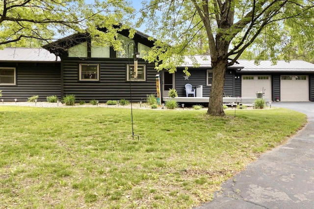 29774 Whispering Pines Rd, Lone Rock, WI 53556 - view of front of home with asphalt driveway, a front yard, an attached garage, and log veneer siding