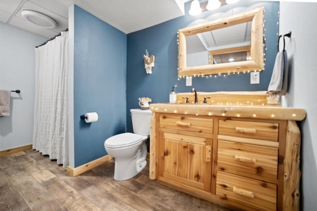 29774 Whispering Pines Rd, Lone Rock, WI 53556 - bathroom featuring wood finished floors, toilet, vanity, baseboards, and curtained shower