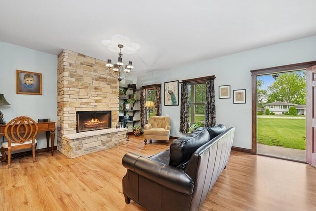 W522 Highland Rd, Genoa City, WI 53128 - living area featuring light wood-type flooring, a chandelier, a fireplace, and baseboards