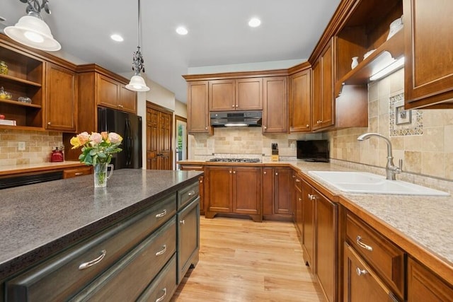 W522 Highland Rd, Genoa City, WI 53128 - kitchen with open shelves, a sink, freestanding refrigerator, under cabinet range hood, and hanging light fixtures