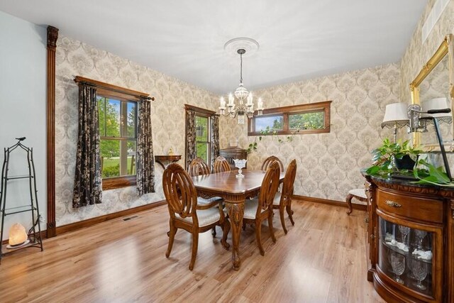 W522 Highland Rd, Genoa City, WI 53128 - dining room with baseboards, a chandelier, wallpapered walls, and light wood finished floors