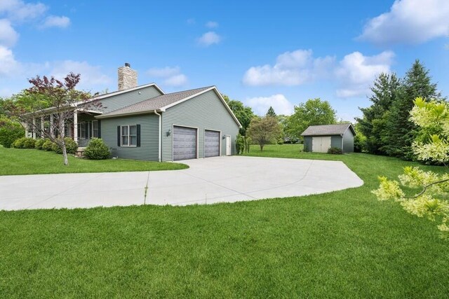 W522 Highland Rd, Genoa City, WI 53128 - view of side of home with a garage, a chimney, a yard, and driveway