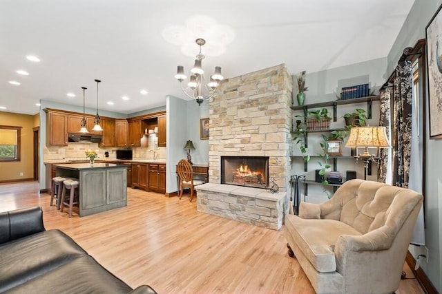 W522 Highland Rd, Genoa City, WI 53128 - living room featuring a stone fireplace, light wood-type flooring, a chandelier, and recessed lighting