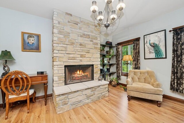 W522 Highland Rd, Genoa City, WI 53128 - sitting room with a chandelier, wood finished floors, a stone fireplace, and baseboards