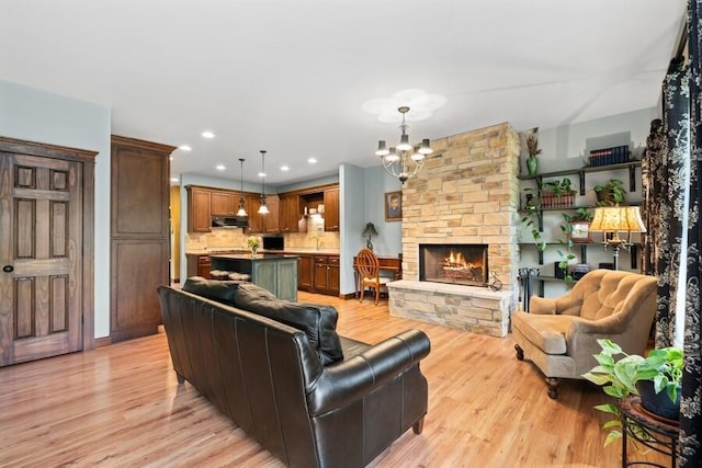 W522 Highland Rd, Genoa City, WI 53128 - living room with a chandelier, light wood-style flooring, a fireplace, and recessed lighting