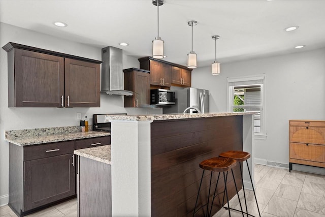 915 E Ohio Ave, Milwaukee, WI 53207 - kitchen with wall chimney exhaust hood, stainless steel appliances, baseboards, dark brown cabinets, and a breakfast bar area