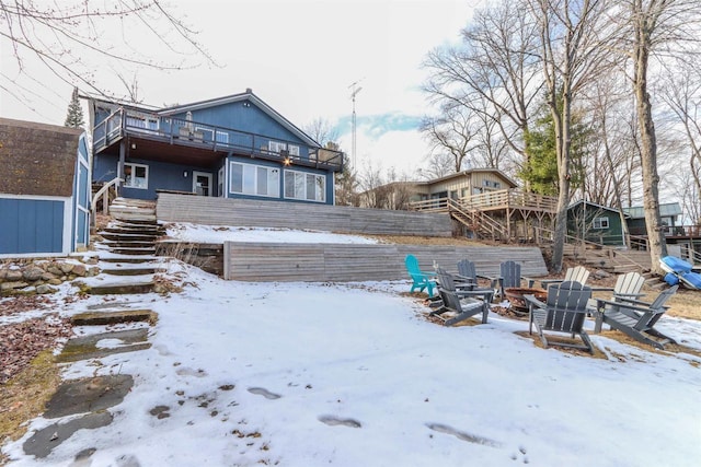N1416 W Stratton Rd, Waupaca, WI 54981 - snow covered back of property with an outdoor fire pit, stairway, and a balcony