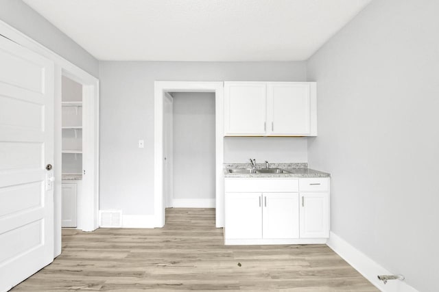 3381 N 26th St Unit 3383, Milwaukee, WI 53206 - bar with a sink, light wood-style floors, and baseboards