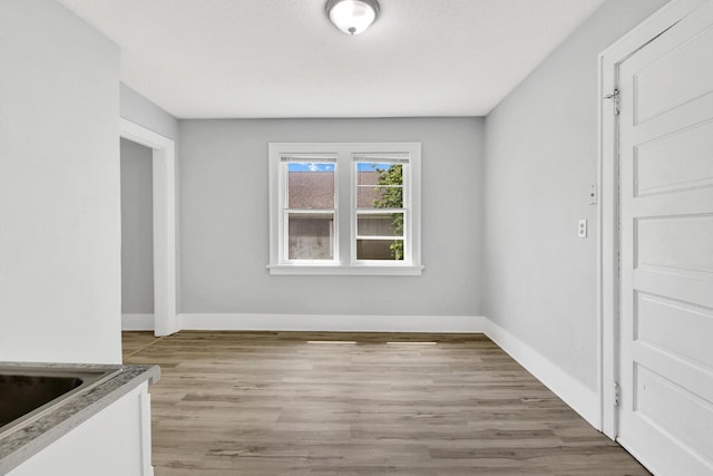 3381 N 26th St Unit 3383, Milwaukee, WI 53206 - unfurnished dining area with light wood-type flooring and baseboards