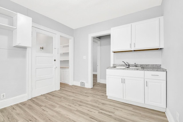 3381 N 26th St Unit 3383, Milwaukee, WI 53206 - kitchen featuring open shelves, baseboards, and white cabinetry