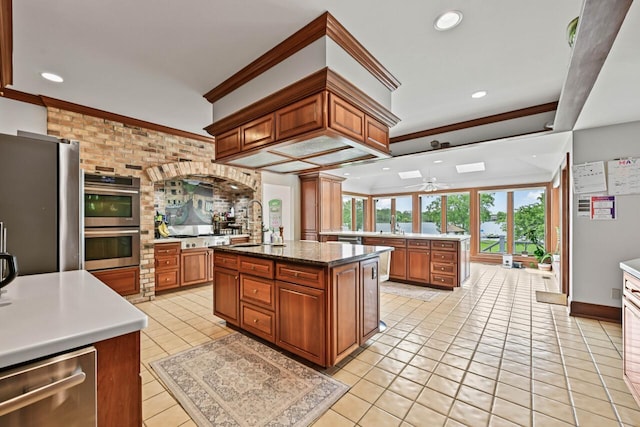 S82W15980 Bass Bay Ln, Muskego, WI 53150 - kitchen featuring stainless steel appliances, ornamental molding, a sink, a ceiling fan, and brown cabinetry
