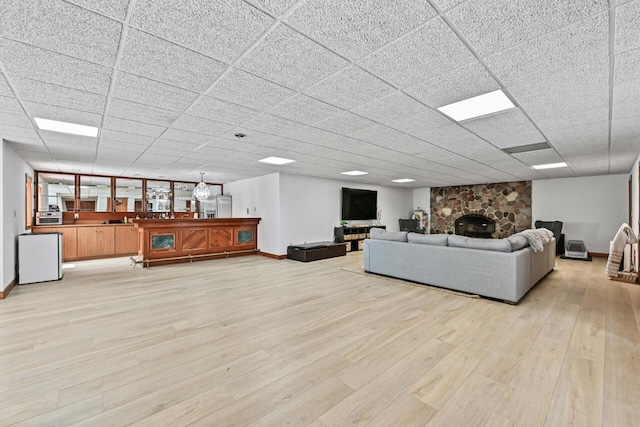 S82W15980 Bass Bay Ln, Muskego, WI 53150 - living area featuring light wood-style floors, baseboards, a paneled ceiling, and a fireplace