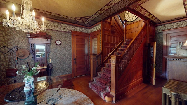 300 S Vine Ave, Marshfield, WI 54449 - foyer entrance featuring wallpapered walls, wood finished floors, stairs, a chandelier, and crown molding