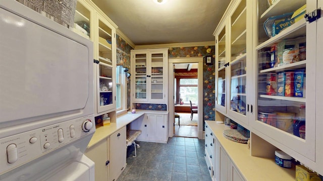 300 S Vine Ave, Marshfield, WI 54449 - interior space with estacked washer and dryer, light countertops, glass insert cabinets, crown molding, and white cabinetry