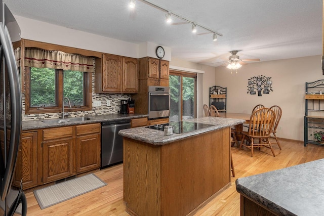 N1440 Red Oaks Dr, La Crosse, WI 54601 - kitchen with appliances with stainless steel finishes, a sink, light wood finished floors, and a center island