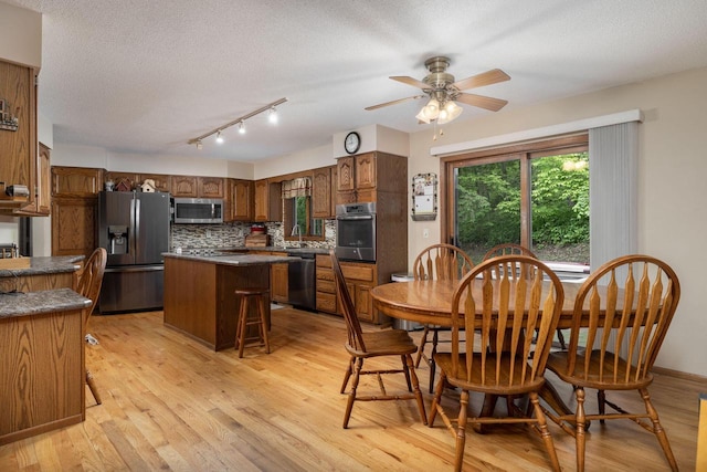 N1440 Red Oaks Dr, La Crosse, WI 54601 - dining area with light wood-style flooring, a textured ceiling, rail lighting, and ceiling fan
