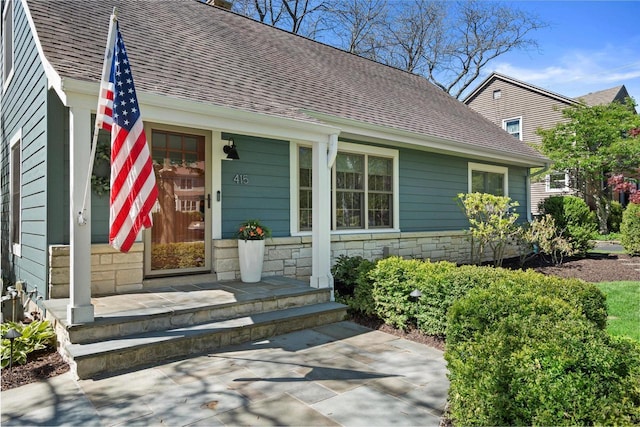 415 E Willow Rd, Fox Point, WI 53217 - property entrance featuring stone siding, roof with shingles, and covered porch