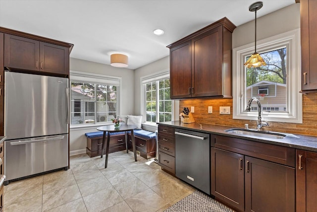 415 E Willow Rd, Fox Point, WI 53217 - kitchen featuring stainless steel appliances, a sink, backsplash, hanging light fixtures, and dark brown cabinetry