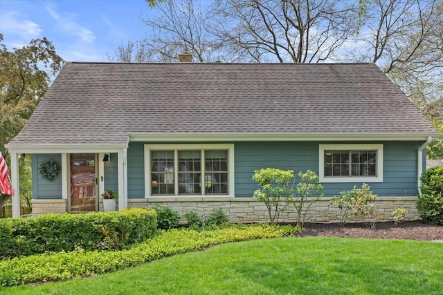 415 E Willow Rd, Fox Point, WI 53217 - view of front facade featuring roof with shingles, a chimney, a front yard, and stone siding