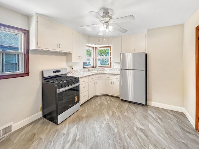 2209 Summit Ave, Racine, WI 53404 - kitchen with stainless steel appliances, a sink, baseboards, ceiling fan, and white cabinetry