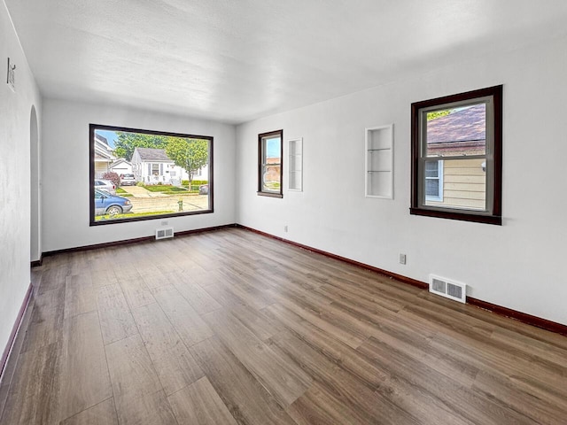 2209 Summit Ave, Racine, WI 53404 - empty room featuring wood finished floors, baseboards, and healthy amount of natural light