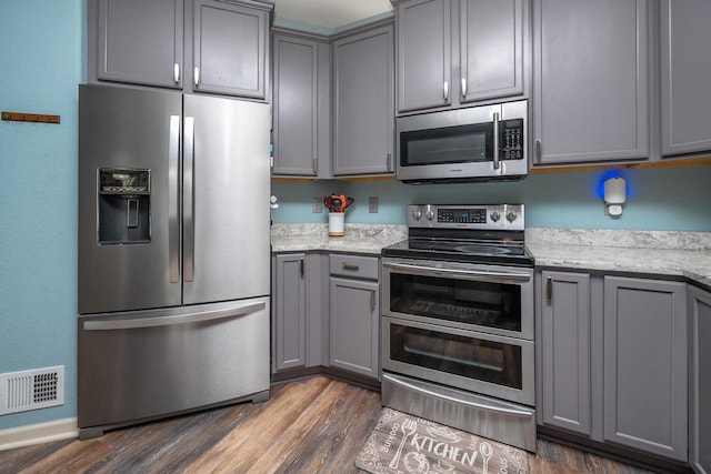 1712 Galena Dr, Port Washington, WI 53074 - kitchen featuring stainless steel appliances, gray cabinets, dark wood-style floors, light stone counters, and baseboards