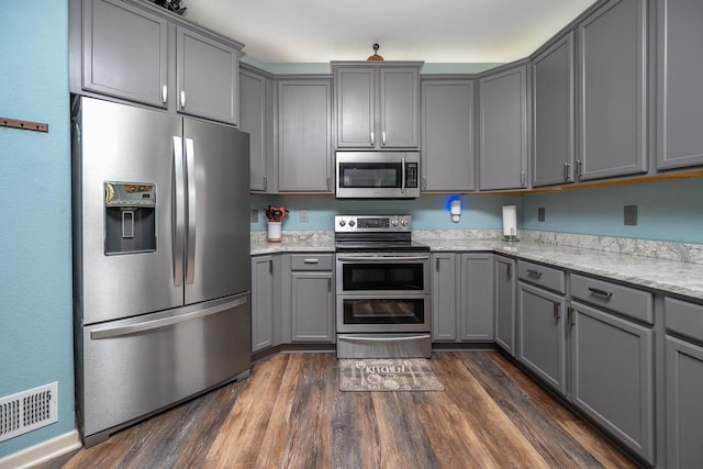 1712 Galena Dr, Port Washington, WI 53074 - kitchen featuring stainless steel appliances, gray cabinetry, light stone counters, and dark wood finished floors