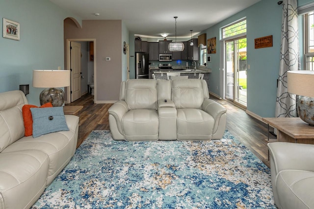 1712 Galena Dr, Port Washington, WI 53074 - living area featuring dark wood-style flooring, baseboards, and arched walkways