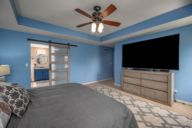 1712 Galena Dr, Port Washington, WI 53074 - carpeted bedroom featuring a barn door, baseboards, ensuite bathroom, a raised ceiling, and a ceiling fan