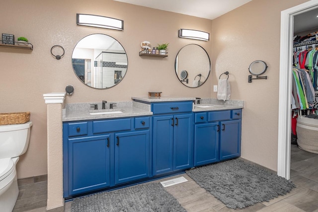 1712 Galena Dr, Port Washington, WI 53074 - full bathroom featuring double vanity, toilet, wood finish floors, and a spacious closet