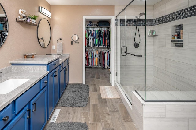 1712 Galena Dr, Port Washington, WI 53074 - full bathroom featuring vanity, a shower stall, a spacious closet, and wood finished floors