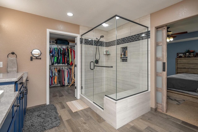 1712 Galena Dr, Port Washington, WI 53074 - full bath featuring a shower stall, wood finished floors, ceiling fan, vanity, and a walk in closet