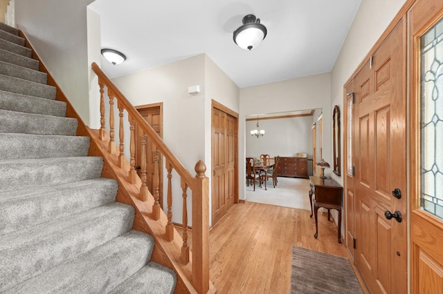 N66W13568 Crestwood Dr, Menomonee Falls, WI 53051 - entrance foyer featuring light wood-type flooring, stairs, and a chandelier